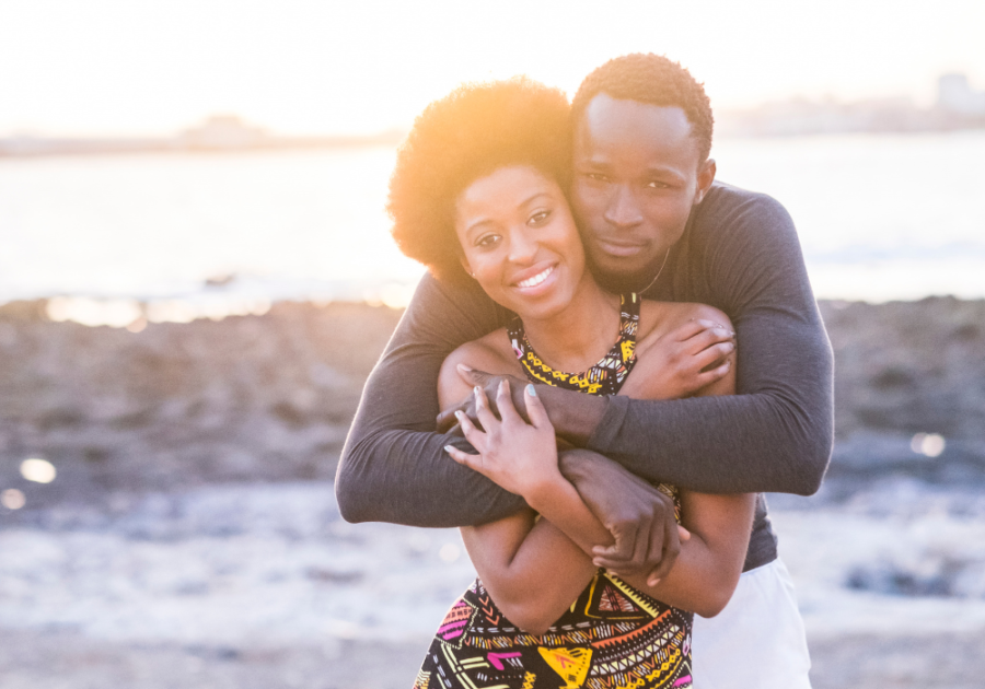 husband back hugging wife while facing the camera signs a player is falling in love