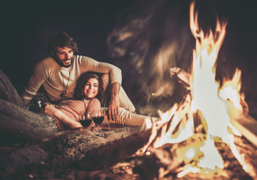 couple sitting by fire outdoors Date Night Ideas for Married Couples