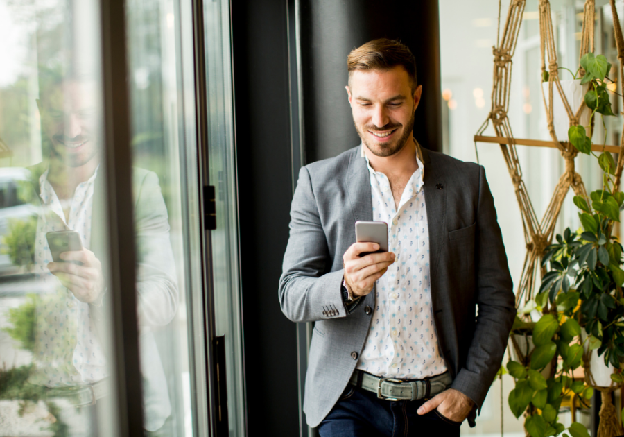 smiling man looking at phone compliments for men