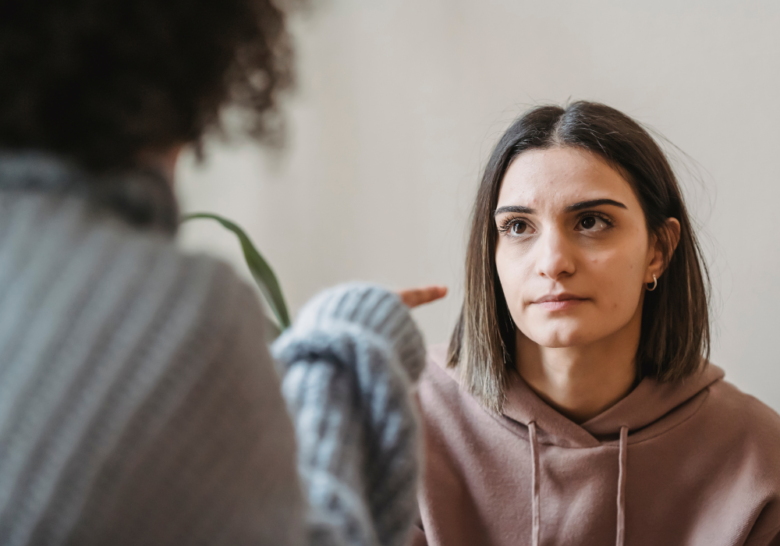 woman pointing finger at friend why are people so mean to me