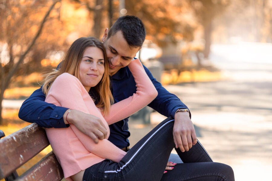 couple cuddling on a park bench